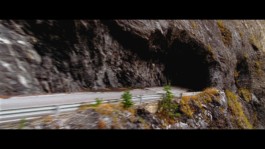 Patrick Seabase riding his track bike on the scenic autumn mountain road of Derborence in Switzerland, surrounded by towering peaks 